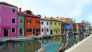 A canal with colorful buildings and boats. - Belvilla by OYO Appartamento ROSSO (Jesolo)