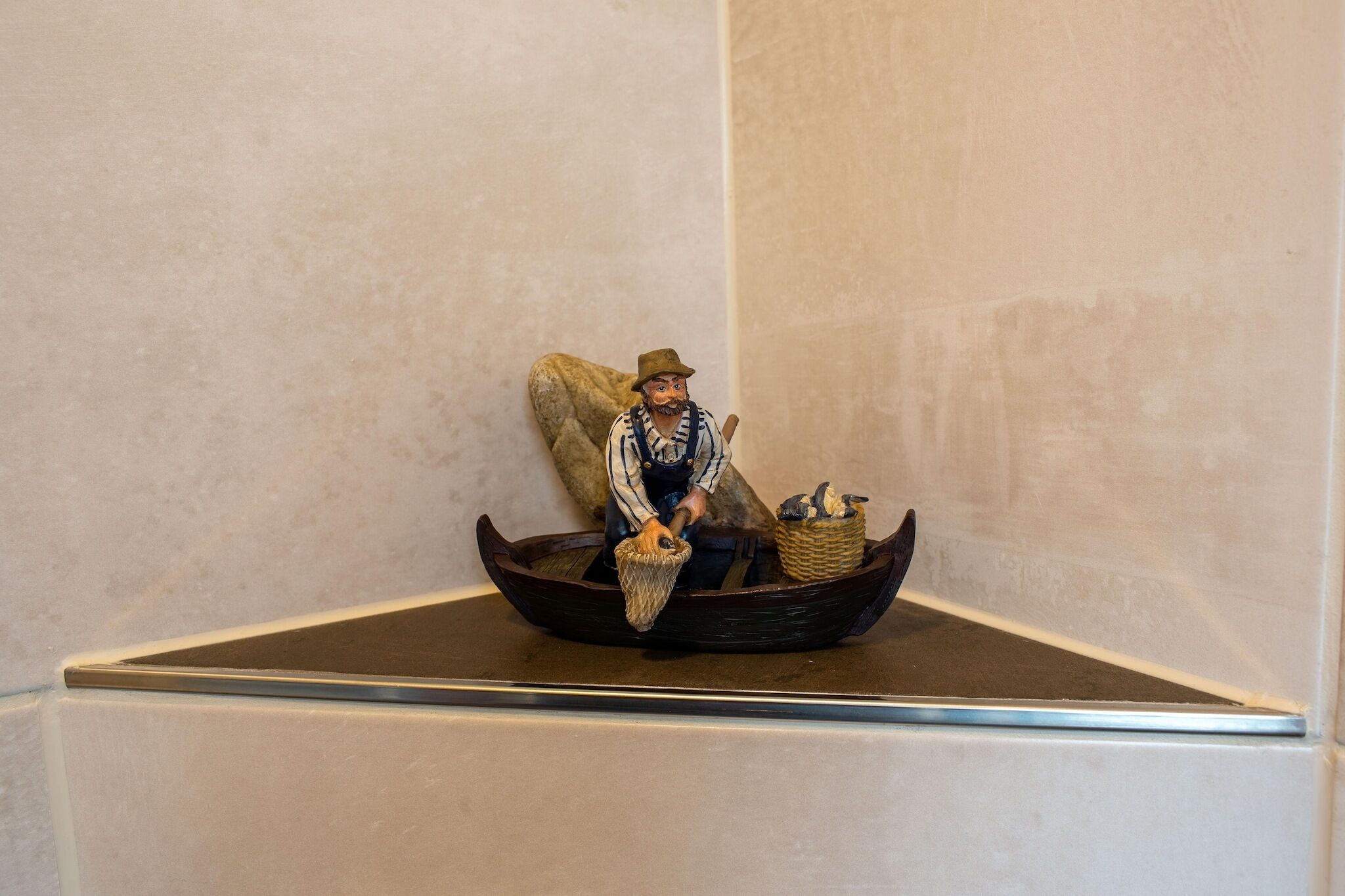 A figurine of a person in a boat with a basket.