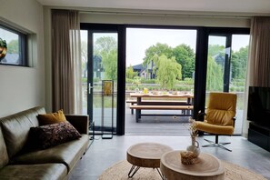 Relax in this inviting living room with a comfortable sofa, armchair, and patio access.