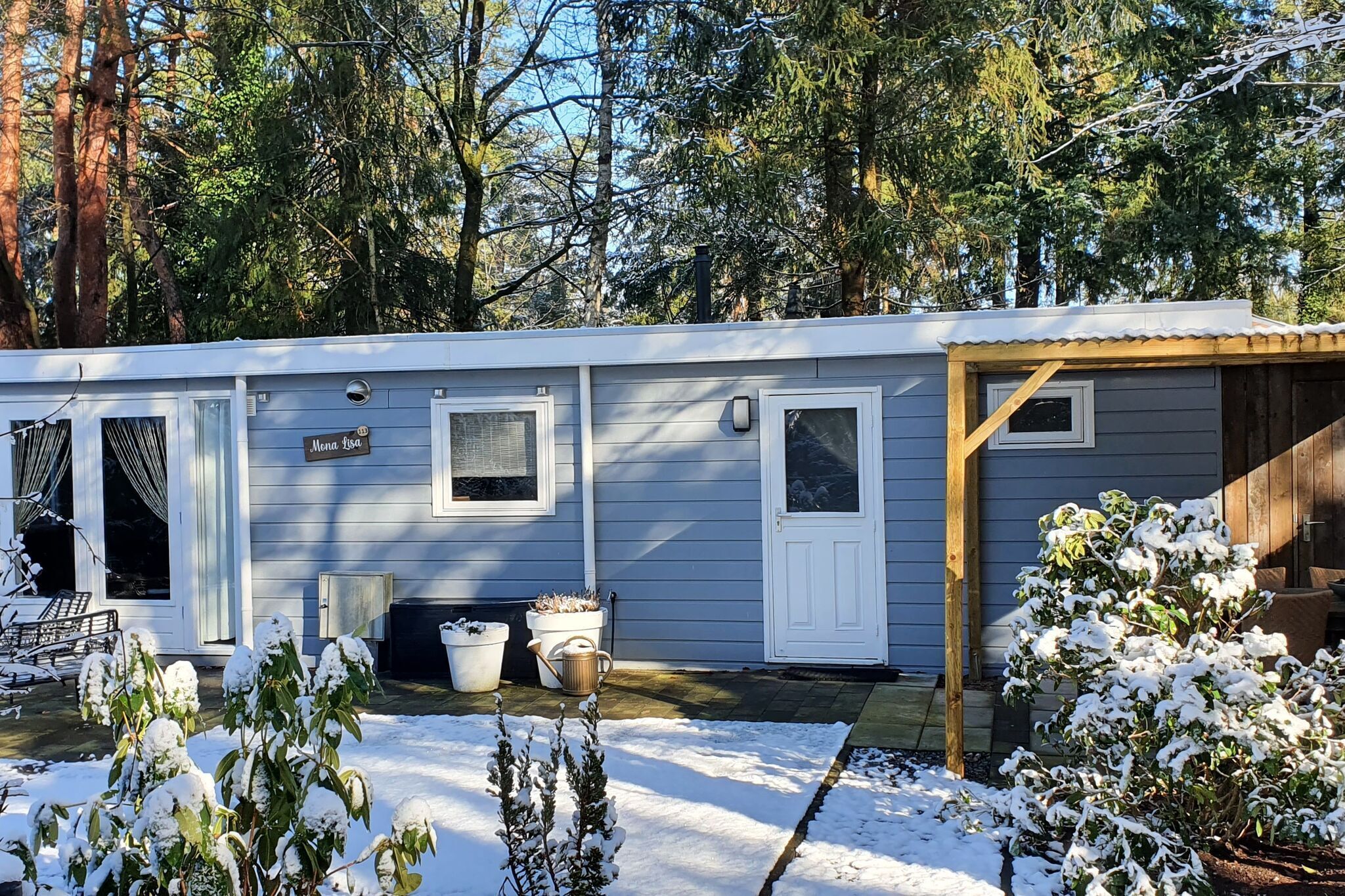 Une maison mobile de plain-pied, dotée d’un porche couvert, d’une porte d’entrée et d’une petite fenêtre.