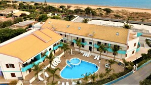 A hotel with a pool, beach view, and multiple floors. - Stylish Apartment by the Sea (Ispica)