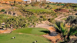Un campo de golf con un hotel al fondo.
