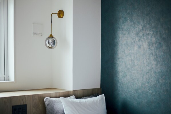 Ein modernes Zimmer mit einer Holzbank, einer Wandleuchte und einer strukturierten Wand.