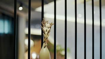 A vase with dried flowers on a wooden ledge, with a blurred indoor background.