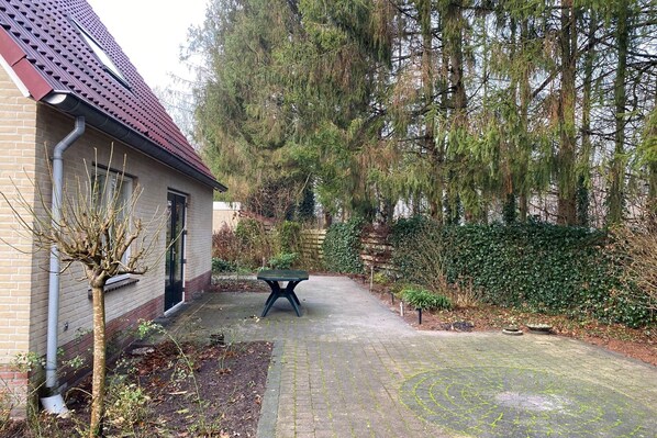 Enjoy a serene outdoor space with a paved walkway, lush greenery, and a tranquil atmosphere.