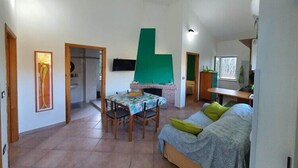 Un salón espacioso con una mesa de comedor, un sofá y una chimenea.