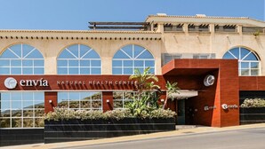 El exterior del Centro de Salud Natural Envía, con un diseño moderno, amplios ventanales arqueados y una entrada destacada.