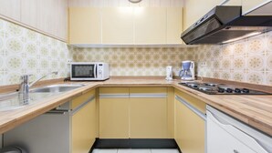 A compact kitchen with a microwave, coffee maker, and stove. - Pretty apartment on the casino (Blankenberge)
