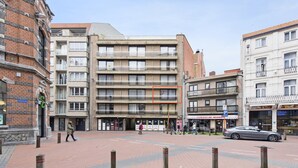 A multi-story building with a brick facade and a flat roof. - Pretty apartment on the casino (Blankenberge)