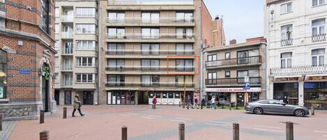 A multi-story building with a brick facade and a flat roof.