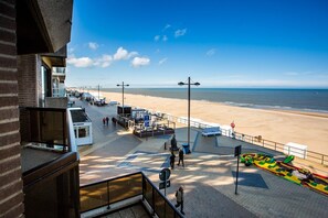 Eine Strandpromenade mit einem Gehweg, Strandstühlen und einem Rettungsschwimmerstand.