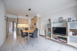 Eine moderne Wohnung mit Essbereich, Küche und Unterhaltungseinheit.