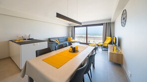 A modern hotel room with a dining area, a sofa set, and a view of the sea. - Apartment with 3 bedrooms and sea view (Middelkerke)