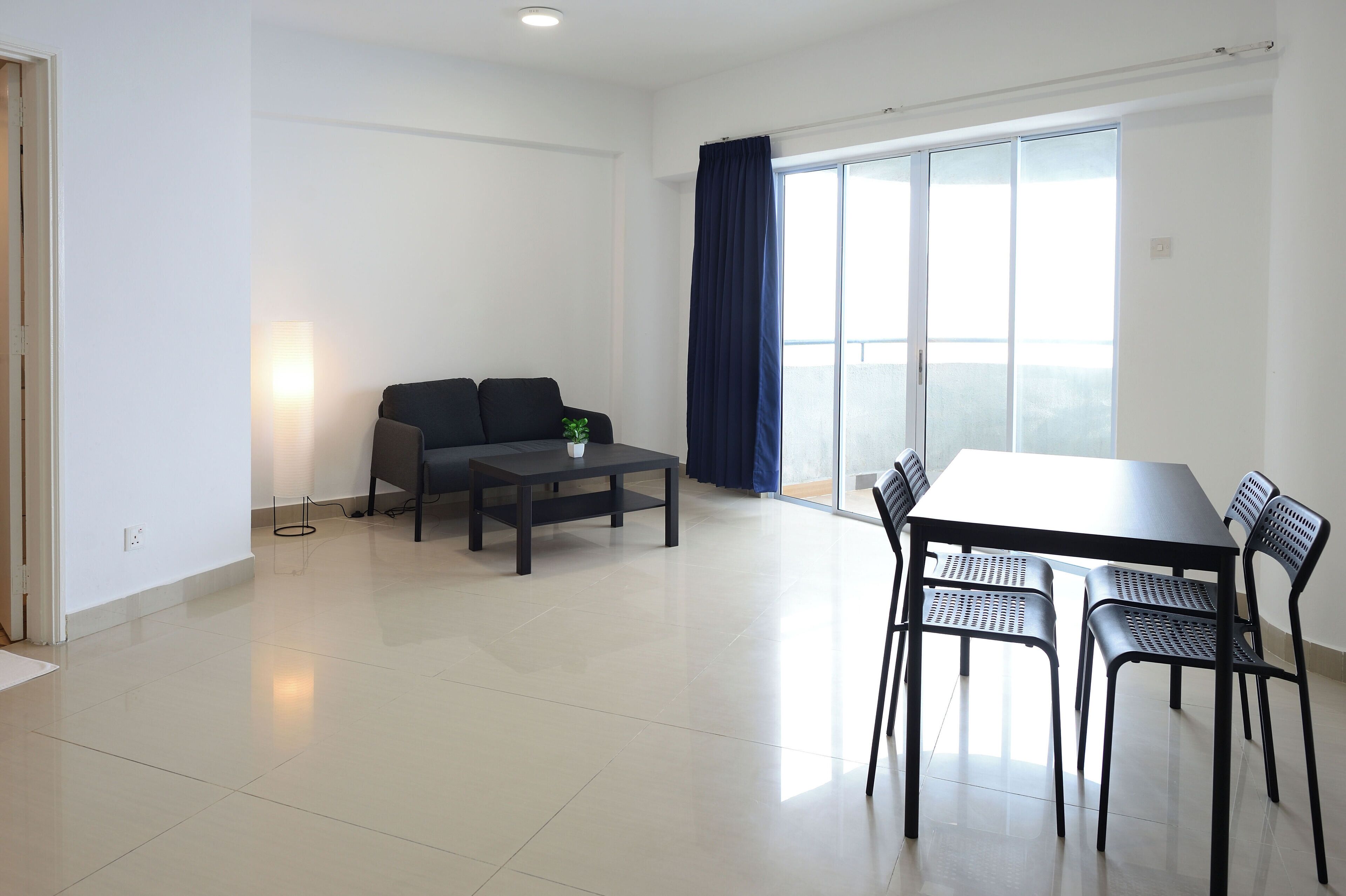 A modern living room with a sofa, a coffee table, and a dining table with chairs.