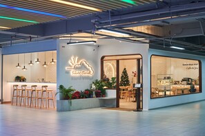 A modern coffee shop with a neon sign, bar seating, and a Christmas tree. - Cloud Forest Homestay Genting Highlands (Genting Highlands)