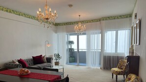 A living room with a dining table, chairs, a sofa, and a chandelier. - Cloud Forest Homestay Genting Highlands (Genting Highlands)