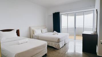 Une chambre d’hôtel avec deux lits, un petit bureau et un balcon avec vue.