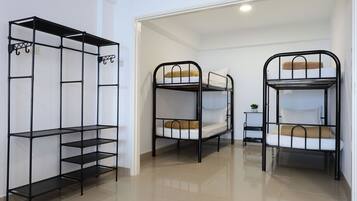 A room with bunk beds and a metal shelving unit.