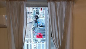 A room with a wooden floor, a red bed, and curtains on the windows. - Naples historic center cozy little house centrally located equipped with every comfort (Napoli)
