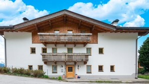 A two-story building with a wooden balcony, a wooden front door, and a clear sky. - Chalet in Gattererberg near Ski Slopes (Stummerberg)