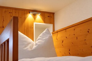 A wooden bunk bed with a headboard and a mirror.