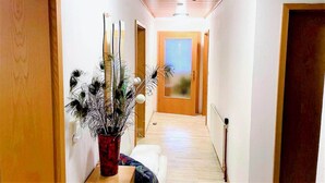 A narrow hallway with wooden floors and white walls, leading to a door with a frosted glass panel. - Chalet in Flattnitz near Ski Slopes & Lakes (Karnten)