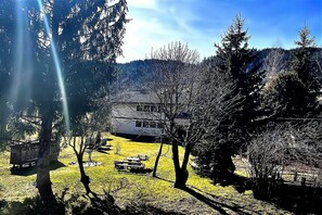 Une maison entourée d’arbres, sous un ciel dégagé.