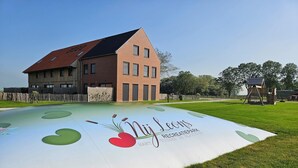 A playground with a sign reading 'Nij Leons Recreatiepark' and a building in the background. - Villa in Friesland with Boat Rental (Leons)