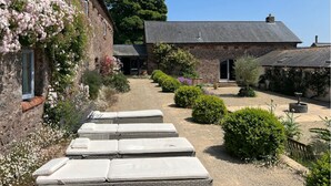 Un bâtiment en pierre avec un chemin de gravier menant à un ensemble de matelas.