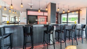 A bar area with black bar stools, a bar counter, and hanging light fixtures. - Holiday Home in Durbuy near Adventure Valley (Durby)