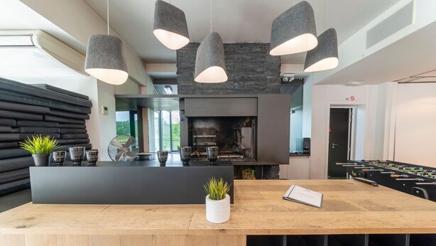 A modern kitchen with a central island, a fireplace, and a foosball table. - Holiday Home in Durbuy near Adventure Valley (Durby)