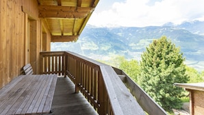 A wooden balcony with a bench, overlooking a mountainous landscape. - Chalet in Gattererberg near Ski Slopes (Stummerberg)
