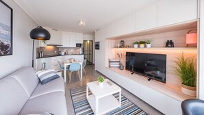 A modern apartment with a living room, dining area, and kitchen.