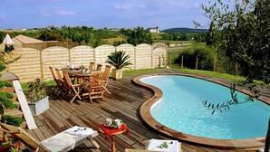 A wooden deck with a pool, surrounded by a fence, and outdoor furniture. - Villa in France with Private Pool & Garden (Chalais)