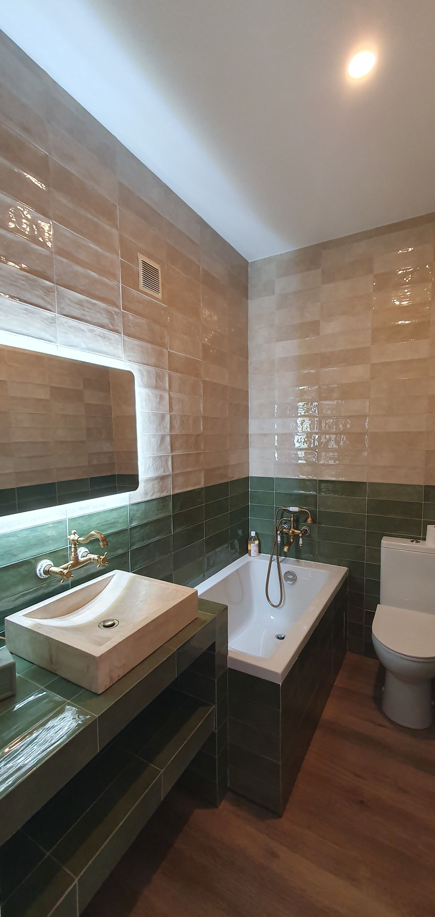 A bathroom with a double sink, a bathtub, and a toilet.