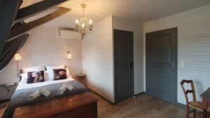 Un dormitorio con cama, lámpara de noche y candelabro.