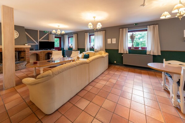 Relax in a spacious room with a plush sofa, flat-screen TV, and cozy fireplace.