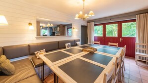 Ein Essbereich mit einem langen Tisch, Bänken und einer Couch.