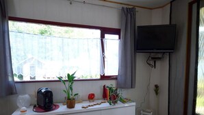 A room with a white desk, a television mounted on the wall, a window with curtains, and a small table with a remote control. - Apartment in Meisberg with In-house Catering (Meisburg)