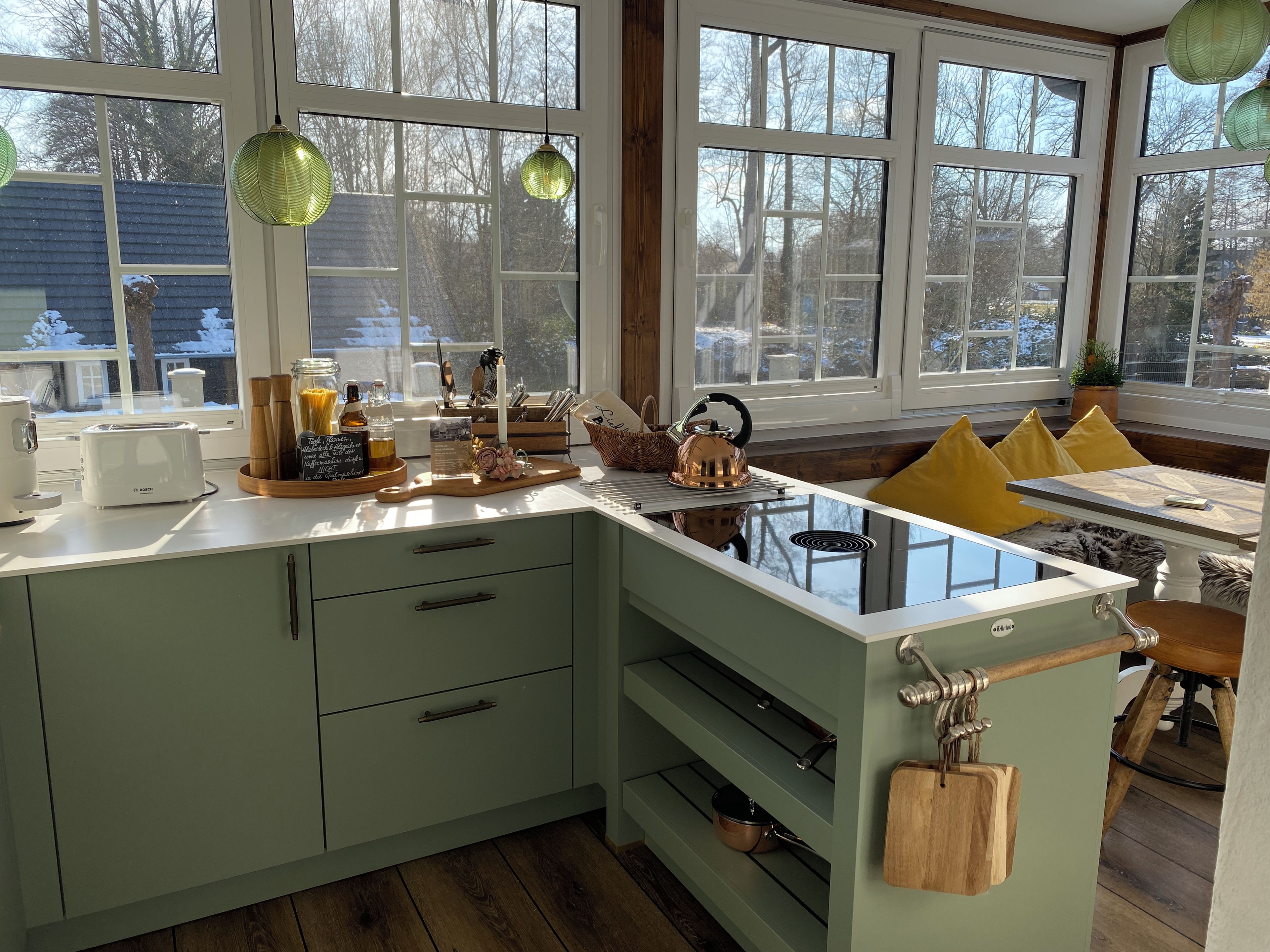 A kitchen with a built-in stove, a toaster, and a kettle on the counter.