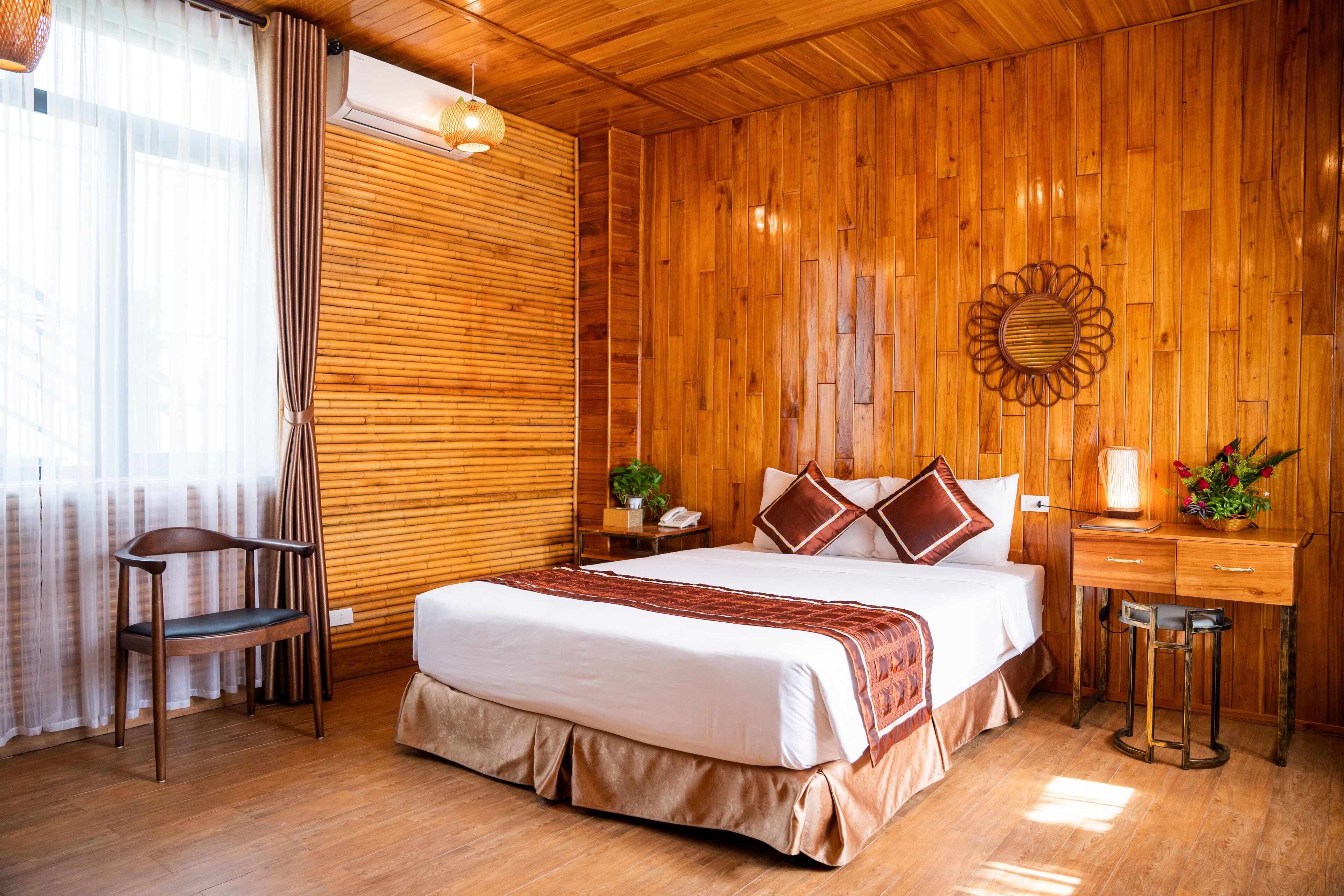 A wooden-paneled room with a bed, a desk, and a chair.
