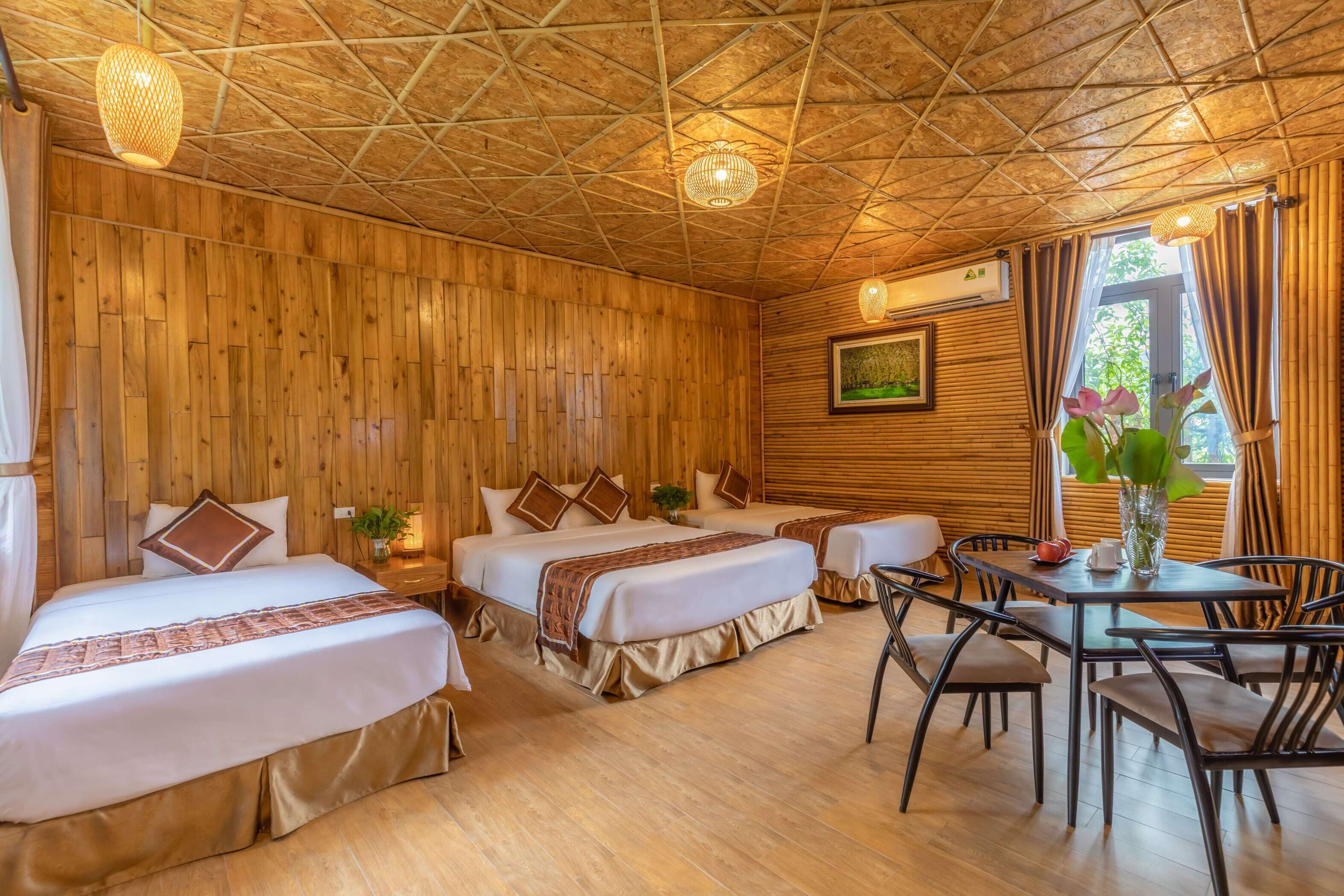 A room with two beds, a dining table, and chairs.