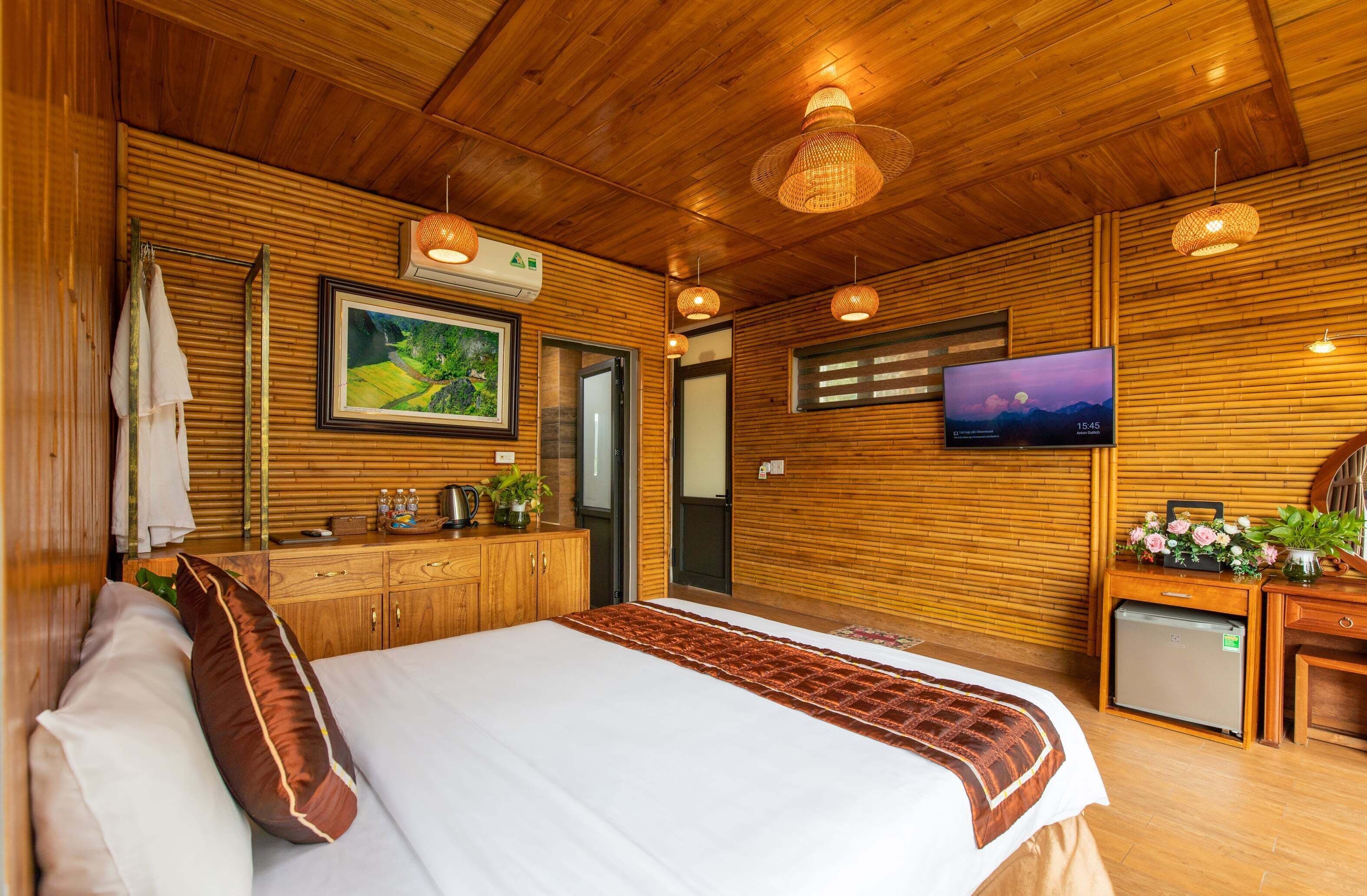 Dormitorio de estilo rústico con cama, televisor y una pequeña kitchenette.