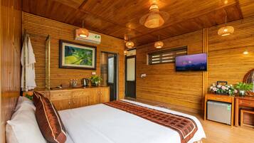 Une chambre à coucher décorée dans un style rustique, avec un lit, une télévision et une petite kitchenette.