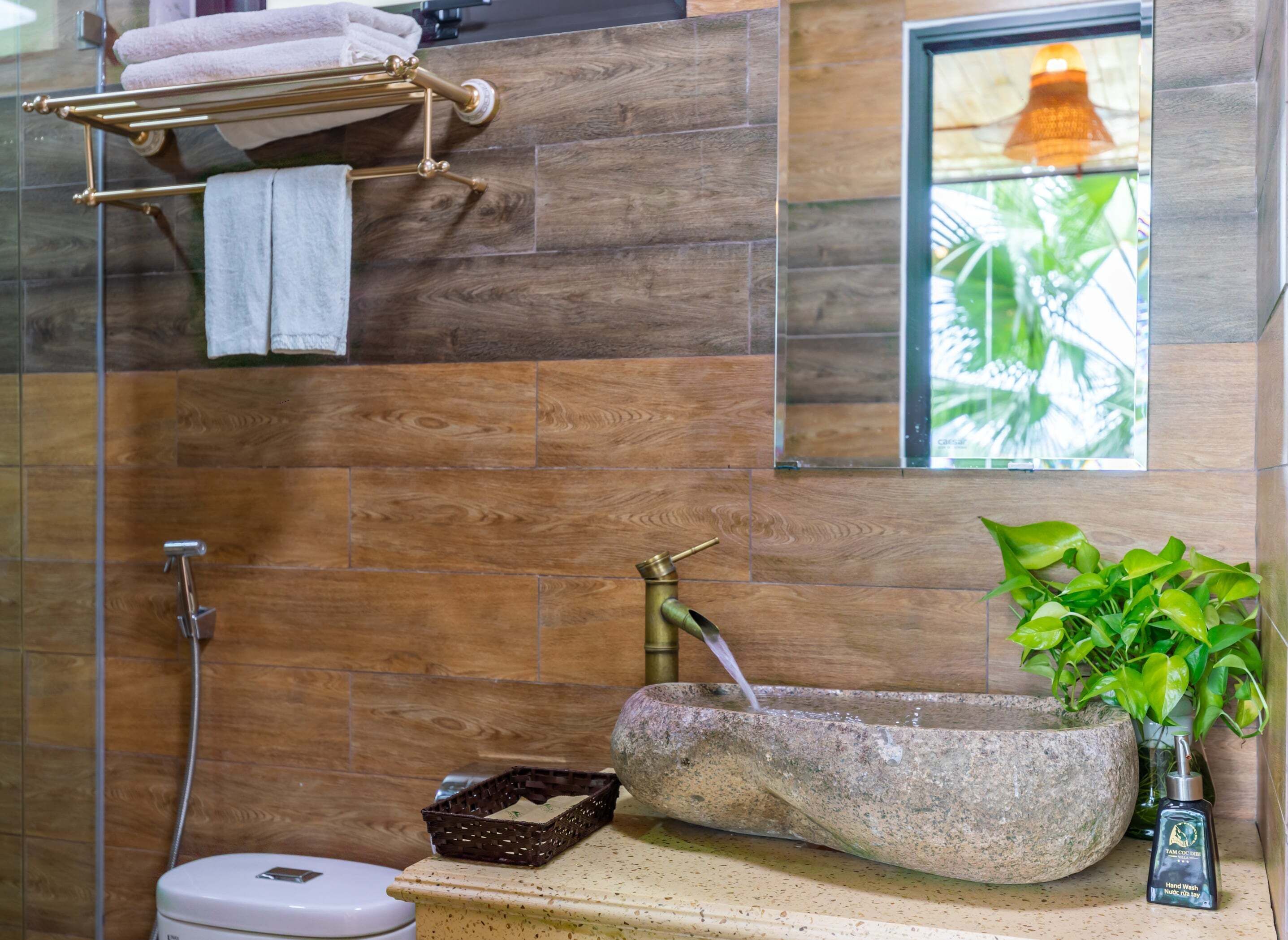 Un bagno con lavabo in pietra, doccia e porta asciugamani.