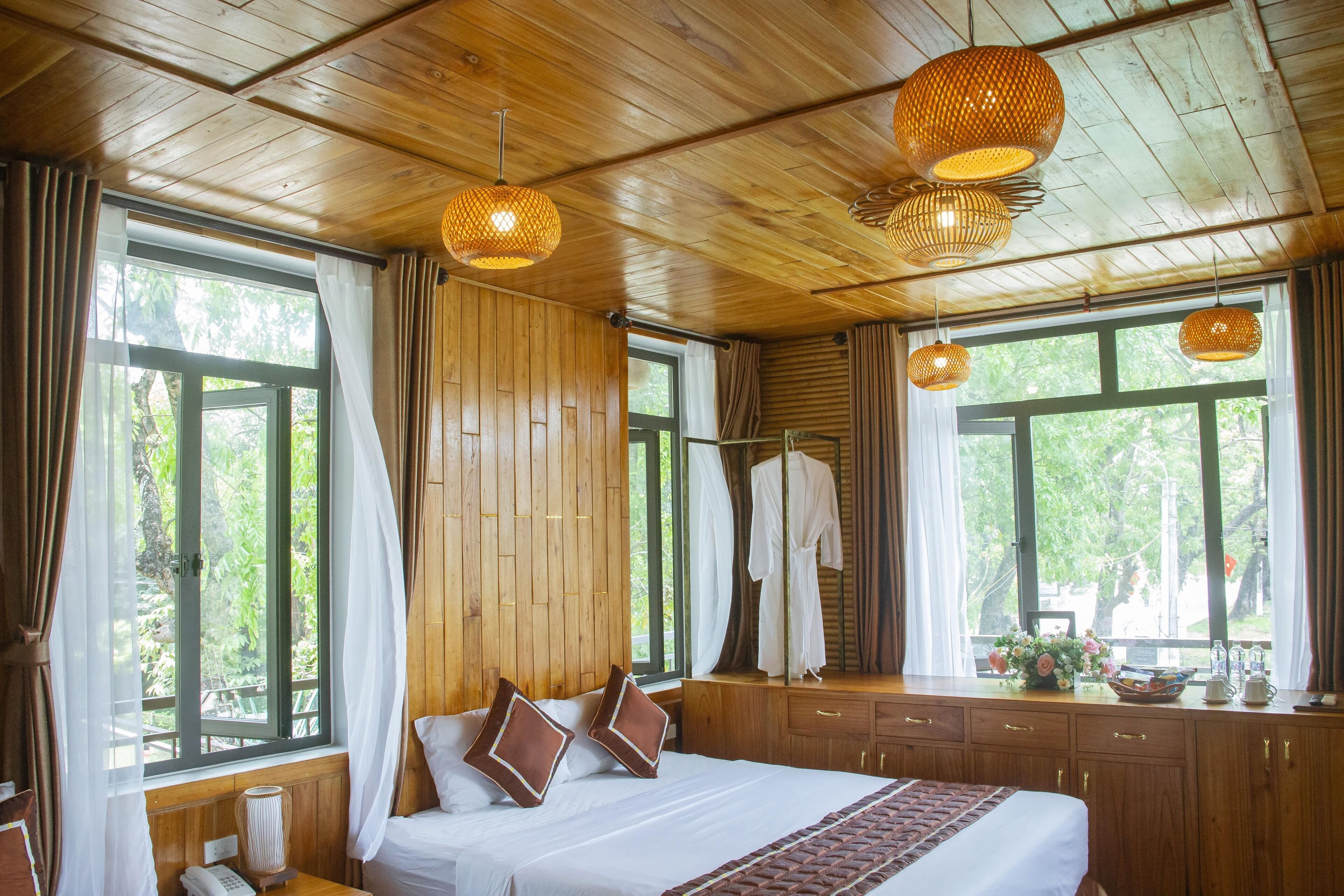 A wooden room with a bed, curtains, and hanging lights.
