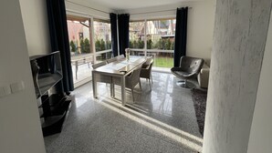 Una habitación moderna con una mesa de comedor, sillas, un sofá y vistas al exterior.
