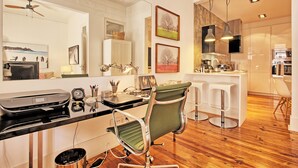 A modern kitchen with a central island, bar stools, and a dining area.