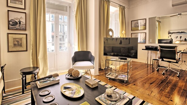 A living room with a TV, a dining table, and a sofa.