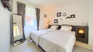 A bedroom with a bed, a mirror, a bedside lamp, and a window with curtains. - BASTINICA KRK Superior Ap 3, OldTown, CityCenter (Krk)